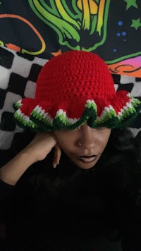 a woman wearing a crocheted watermelon hat