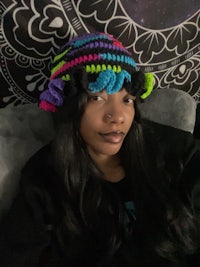 a black woman wearing a colorful crocheted hat